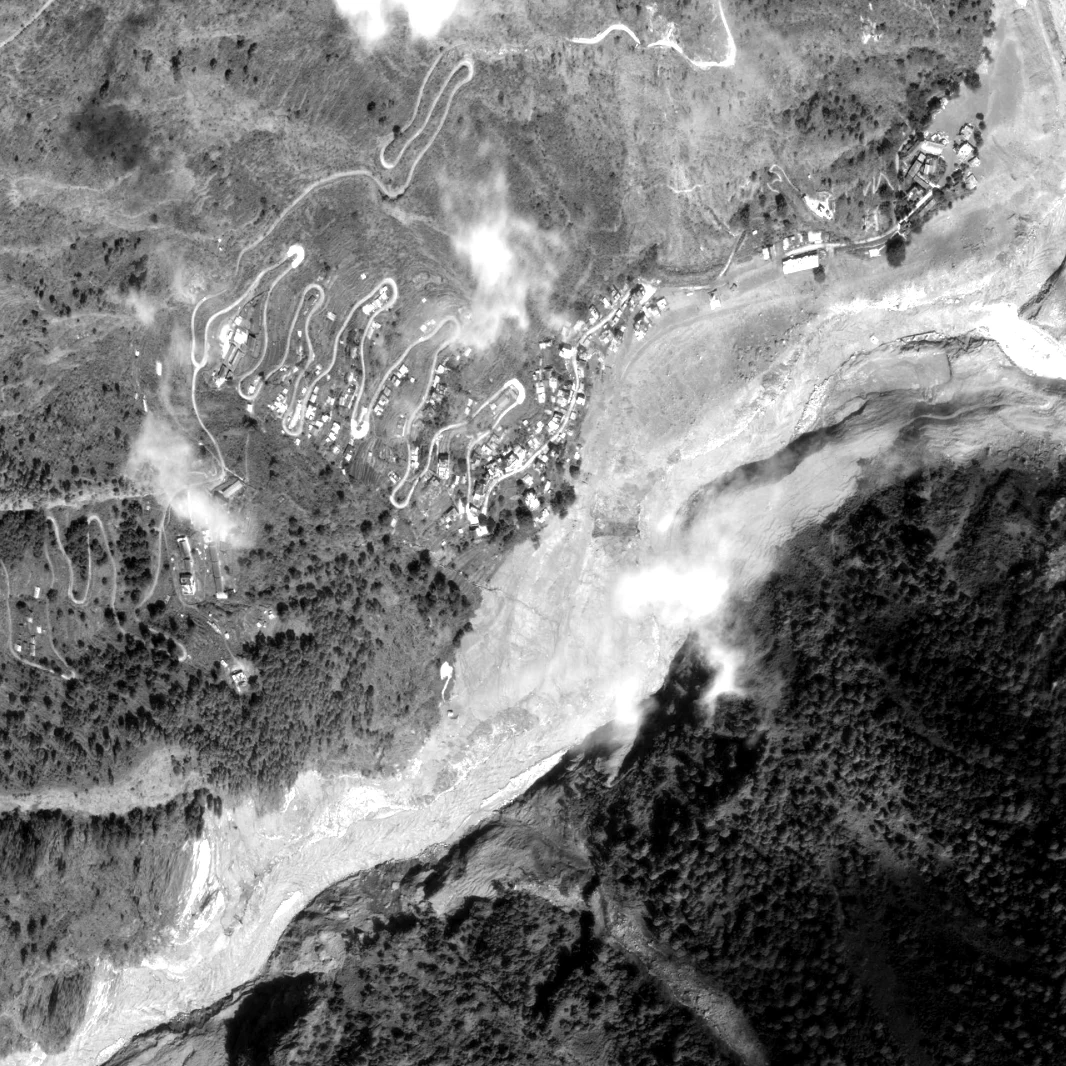 Syabrubesi confluence on 27 August 2026, one day after the flood, braided debris sheet across the valley floor